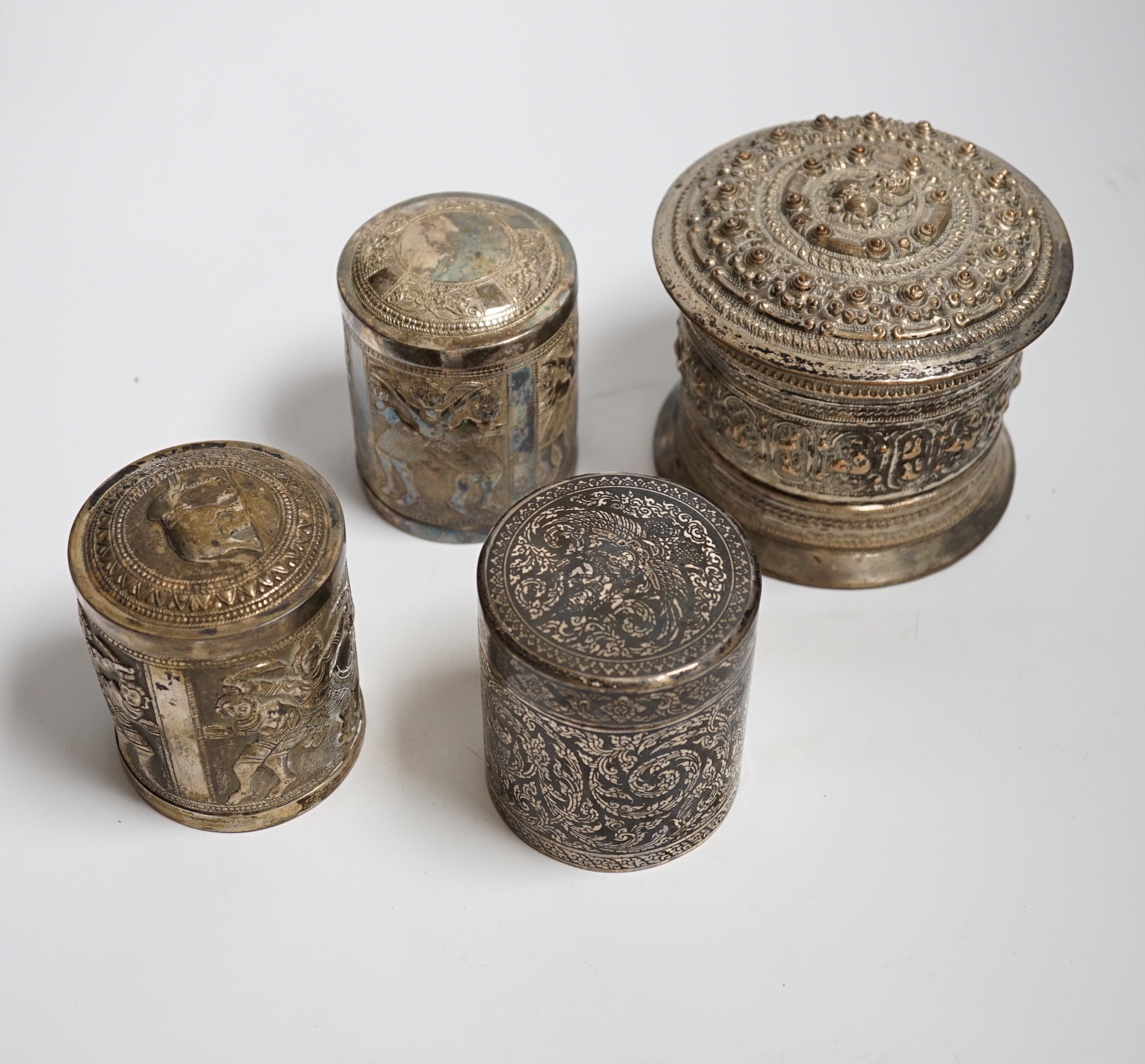 Three Burmese white metal boxes, and a Thai silver and niello work box, tallest 11cm